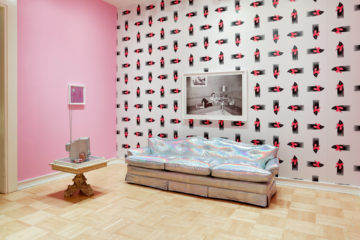 <p>Sadie Barnette, <i>Room to Live</i>, 2019. Mixed media installation, holographic vinyl sofa, metal flake TV, archival inkjet prints, metal flake security cameras. Courtesy of the artist. Installation view of <i>In Plain Sight</i>, 2019, Henry Art Gallery, University of Washington, Seattle. Photo: Mark Woods.</p>
