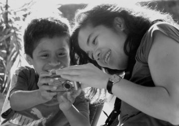 <p>Carina A. del Rosario teaching a young boy. Image credit: Shelly Schmidt. </p>
